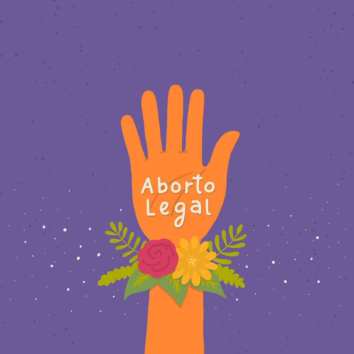 Mano naranja como la campaña por el aborto legal, con las palabras "Aborto Legal" escritas y flores en la muñeca.